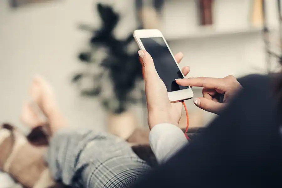 Relaxing on sofa looking at smart phone